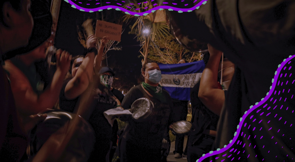 Fotografía de una manifestación de mujeres, se ve en el centro a una mujer on cubrebocas y a otra mujer que sostiene la bandera de El Salvador. Los bordes de la imagen tienen ornamentos digitales, lineas curvas en color morado y menta.